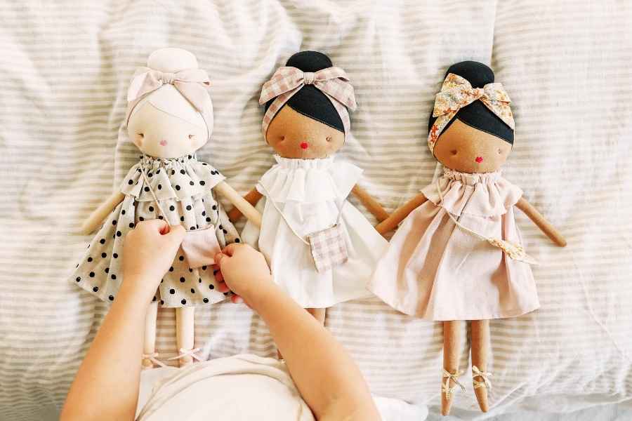 Child playing with 3 dolls
